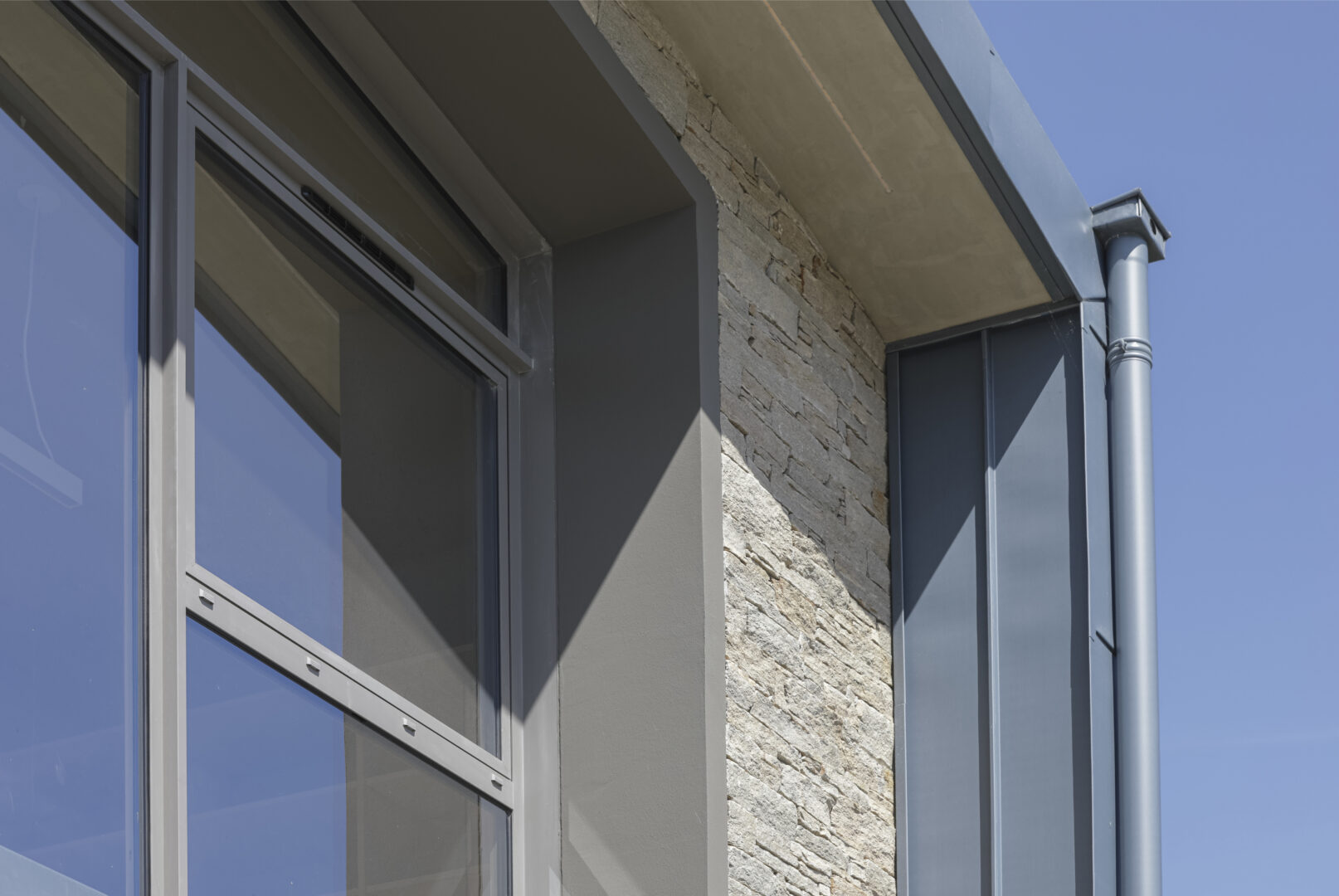Le mariage du béton banché, du zinc et de la pierre : une alliance pour une maison durable et esthétique